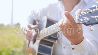 人弹吉他，唱自然.. 吉他手触摸吉他弦。 近距离射击。
